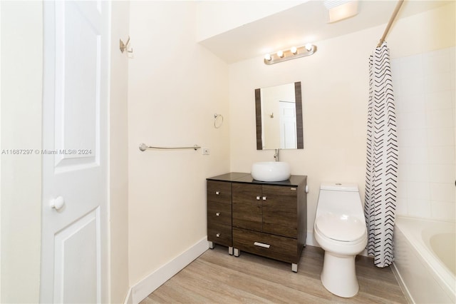 full bathroom featuring toilet, hardwood / wood-style flooring, vanity, and shower / tub combo