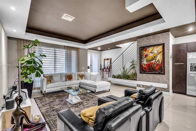 living room with light tile patterned floors and a raised ceiling