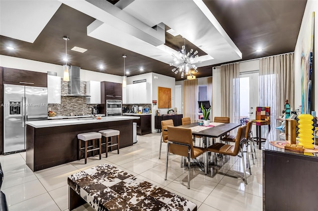 tiled dining space with sink and a notable chandelier