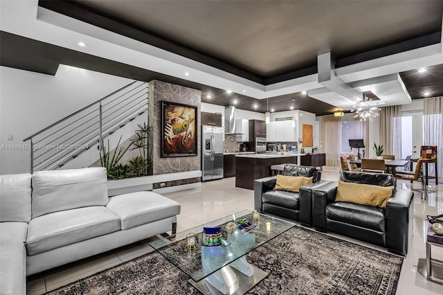 living room featuring coffered ceiling, a notable chandelier, a tray ceiling, and light tile patterned floors