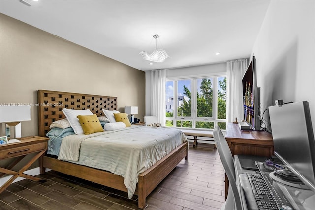 bedroom with a chandelier and dark hardwood / wood-style flooring