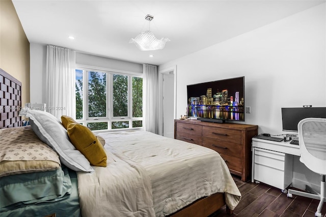 bedroom with a notable chandelier and dark hardwood / wood-style flooring