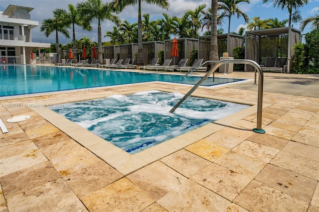 view of swimming pool with a patio and a community hot tub