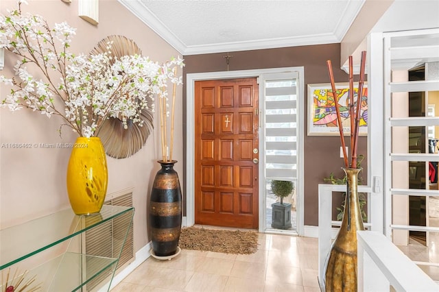 entrance foyer featuring ornamental molding, a textured ceiling, and plenty of natural light