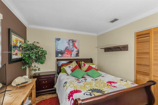 bedroom featuring ornamental molding, hardwood / wood-style floors, a textured ceiling, and a closet