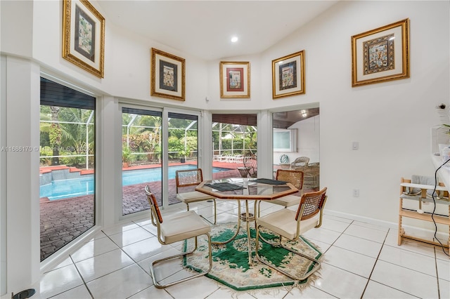 tiled dining room featuring lofted ceiling and a healthy amount of sunlight