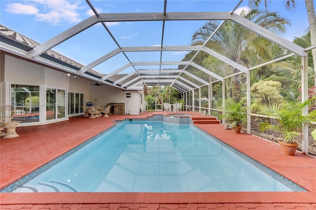 view of pool featuring an in ground hot tub, a patio, and glass enclosure