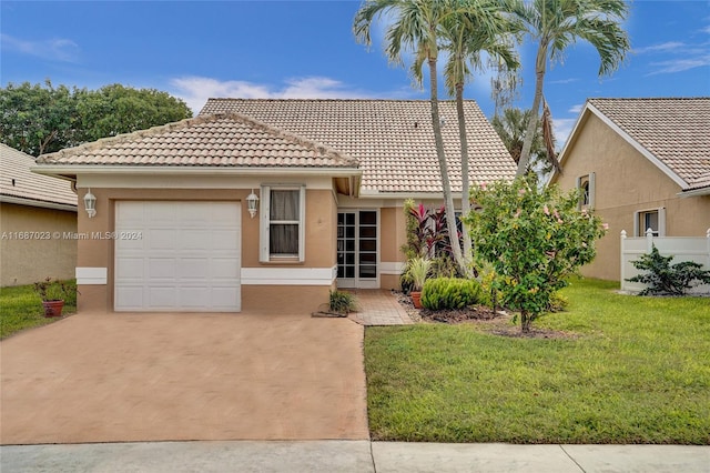 mediterranean / spanish-style house featuring a front yard and a garage