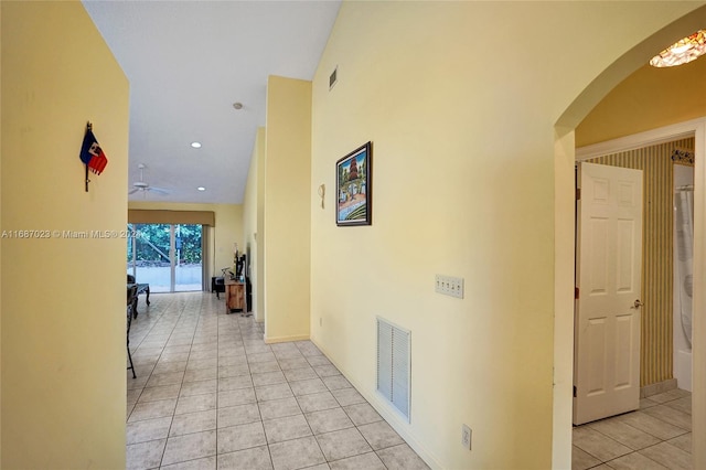 hall with high vaulted ceiling and light tile patterned floors