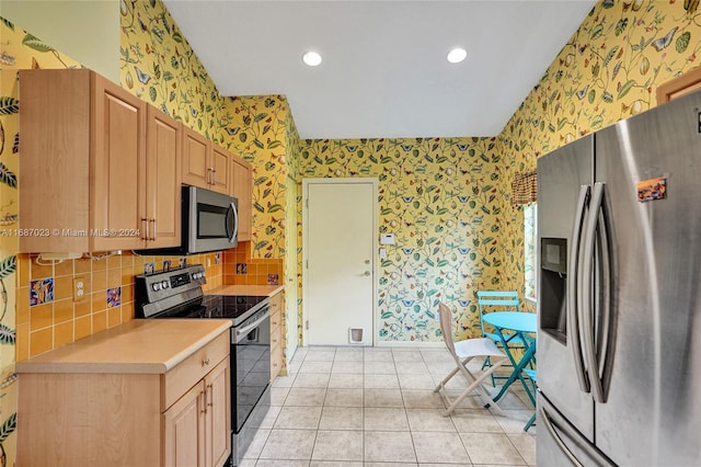 kitchen with light brown cabinets, light tile patterned floors, and stainless steel appliances