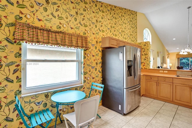 kitchen with stainless steel fridge, a healthy amount of sunlight, sink, and light tile patterned floors