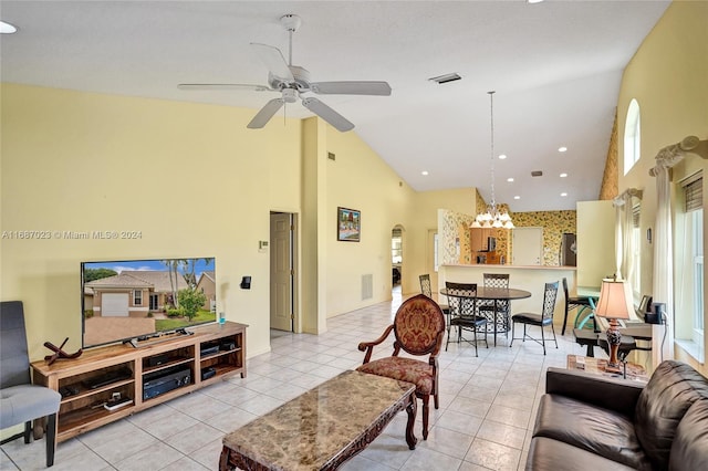 tiled living room featuring ceiling fan with notable chandelier and high vaulted ceiling