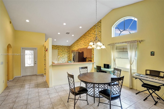 dining room with light tile patterned floors, a healthy amount of sunlight, and lofted ceiling