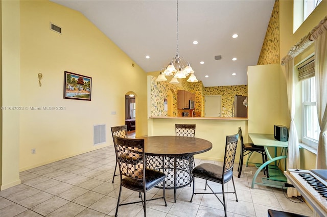 dining space featuring a notable chandelier, light tile patterned floors, and high vaulted ceiling