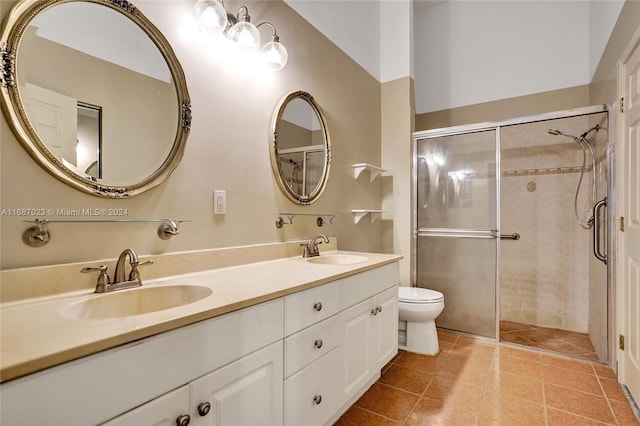 bathroom featuring tile patterned flooring, toilet, an enclosed shower, and vanity