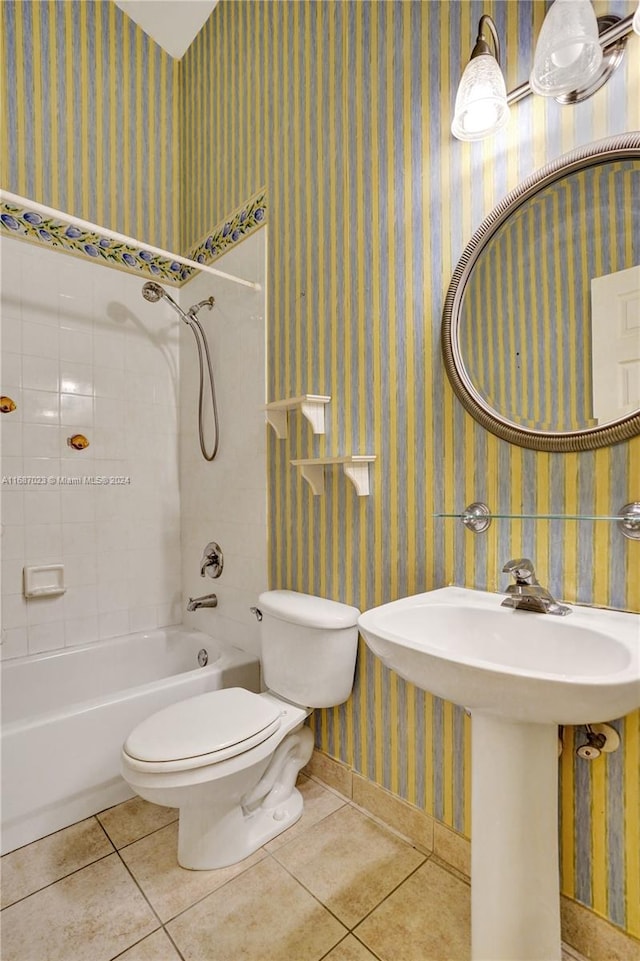 full bathroom with tile patterned floors, tiled shower / bath combo, toilet, and sink