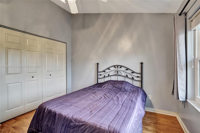 bedroom featuring light hardwood / wood-style floors, vaulted ceiling, a closet, and ceiling fan