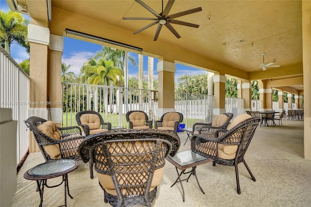 view of patio featuring ceiling fan and an outdoor living space with a fire pit