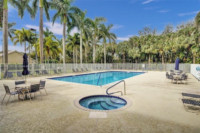 view of swimming pool with a patio and a hot tub