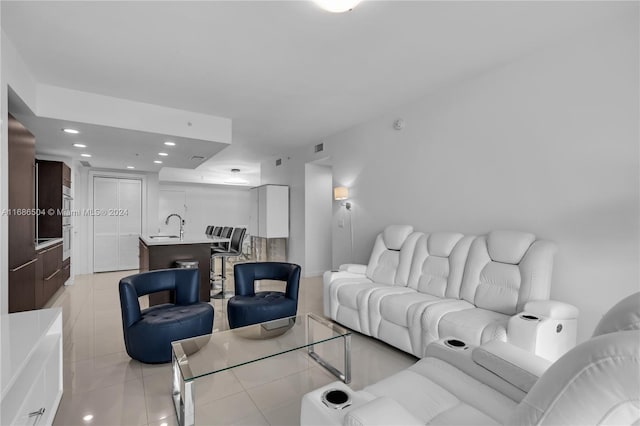 living room featuring sink and light tile patterned floors