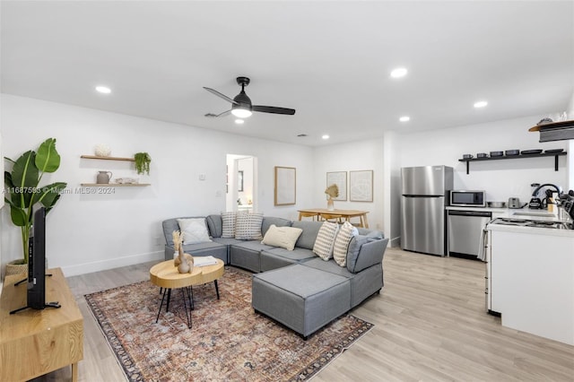 living room featuring ceiling fan and light hardwood / wood-style flooring