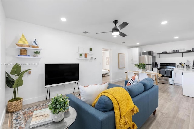 living room with light hardwood / wood-style floors and ceiling fan