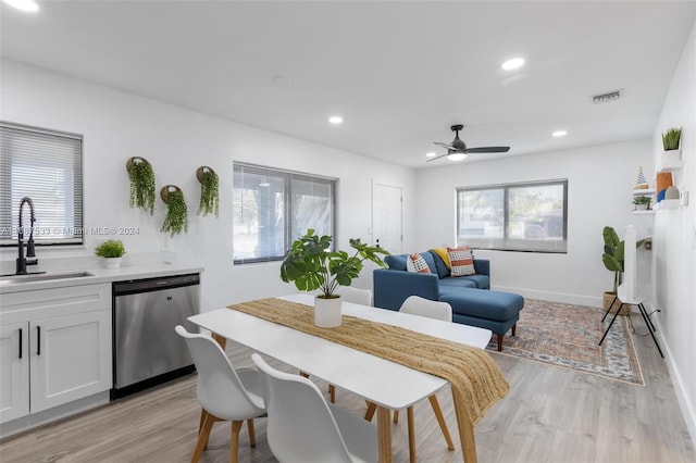 dining room featuring sink, light wood-type flooring, and ceiling fan