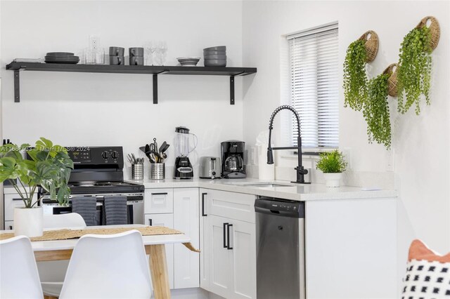 kitchen with appliances with stainless steel finishes, white cabinets, and sink