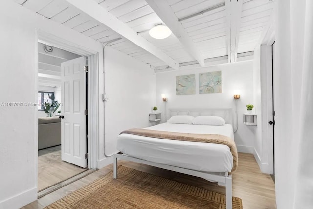 bedroom featuring light hardwood / wood-style floors, beamed ceiling, and wooden ceiling