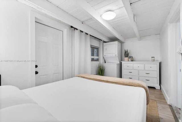 bedroom with wood ceiling, beam ceiling, light hardwood / wood-style flooring, a closet, and stacked washer and clothes dryer