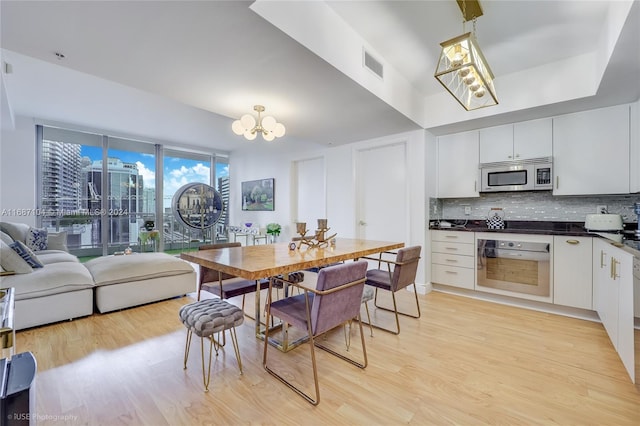 dining space with a notable chandelier and light hardwood / wood-style flooring