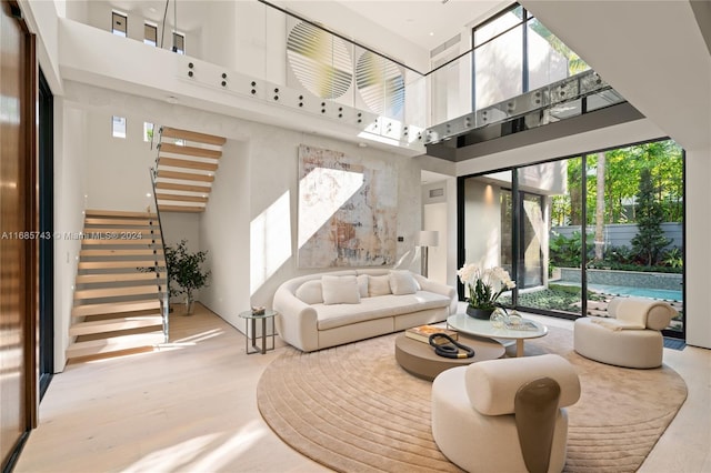 living room featuring light hardwood / wood-style flooring and a towering ceiling