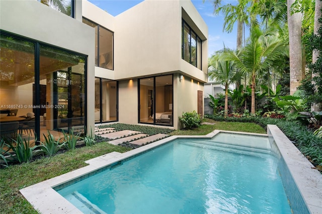 rear view of property featuring pool water feature