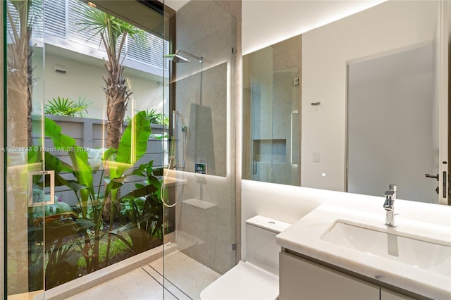 bathroom featuring vanity, toilet, and a shower with door