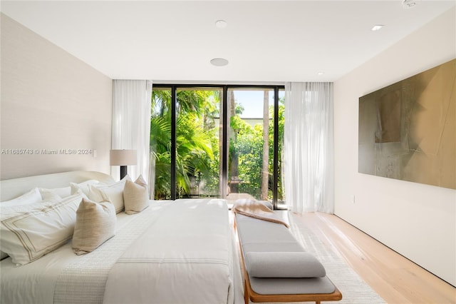 bedroom featuring expansive windows and wood-type flooring