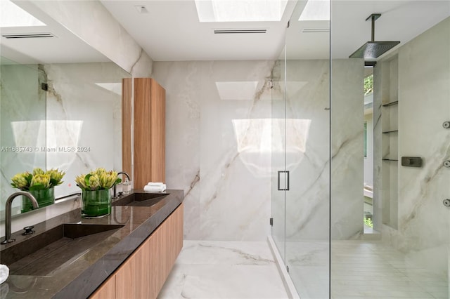 bathroom with vanity, a shower with door, and a skylight