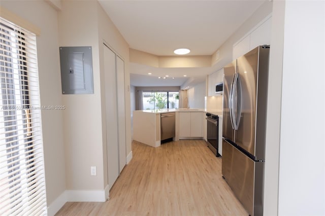 kitchen with light countertops, appliances with stainless steel finishes, electric panel, and white cabinets