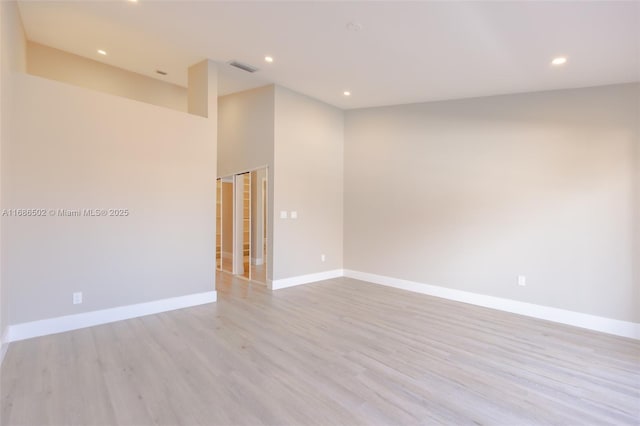 unfurnished room featuring light wood-type flooring, visible vents, baseboards, and recessed lighting