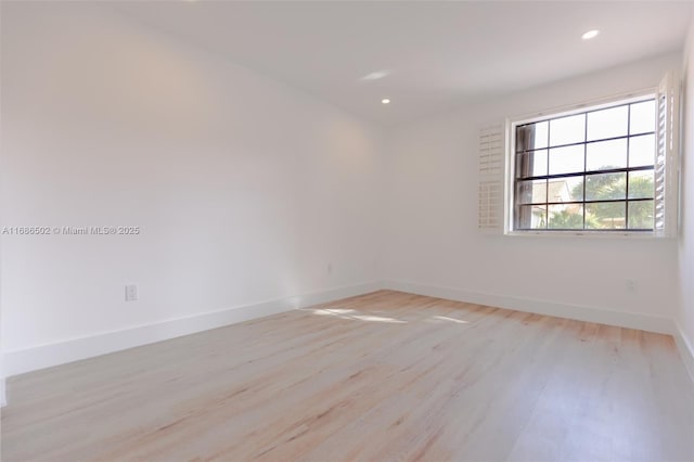 spare room with recessed lighting, light wood-type flooring, and baseboards