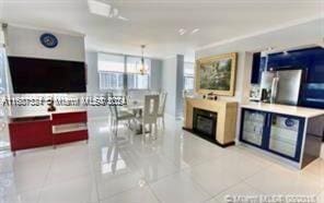 kitchen featuring stainless steel fridge, light tile patterned flooring, and decorative light fixtures