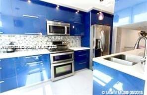 kitchen featuring appliances with stainless steel finishes, blue cabinetry, sink, and backsplash