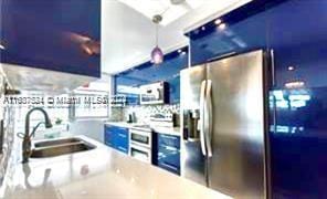 1833 S Ocean Dr Unit Ph1, Hallandale Beach, FL 33009 - kitchen featuring appliances with stainless steel finishes, blue cabinetry, pendant lighting, and light countertops
