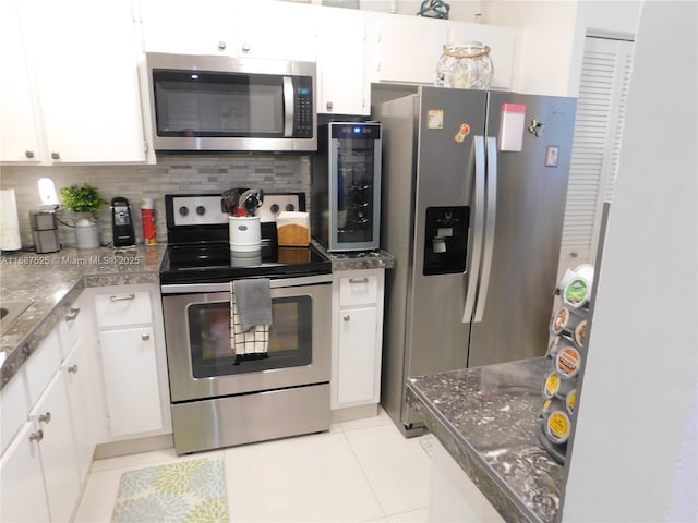 kitchen featuring white cabinetry, light tile patterned floors, tasteful backsplash, and appliances with stainless steel finishes