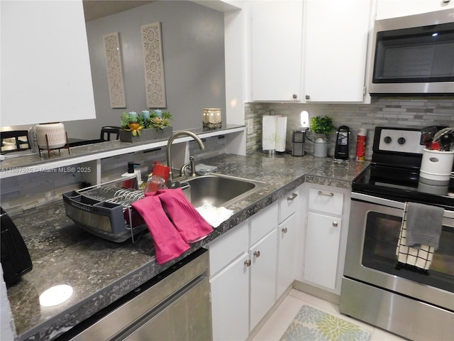 kitchen with sink, decorative backsplash, white cabinets, and appliances with stainless steel finishes