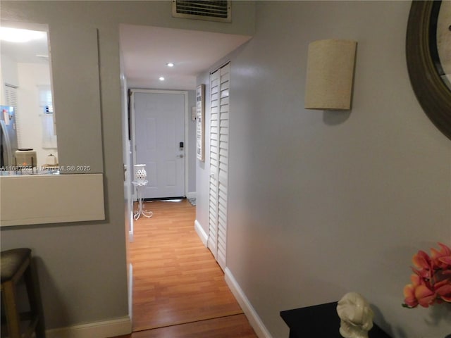 hallway featuring recessed lighting, visible vents, baseboards, and light wood-style flooring