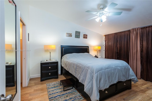 bedroom featuring ceiling fan, light hardwood / wood-style flooring, and vaulted ceiling