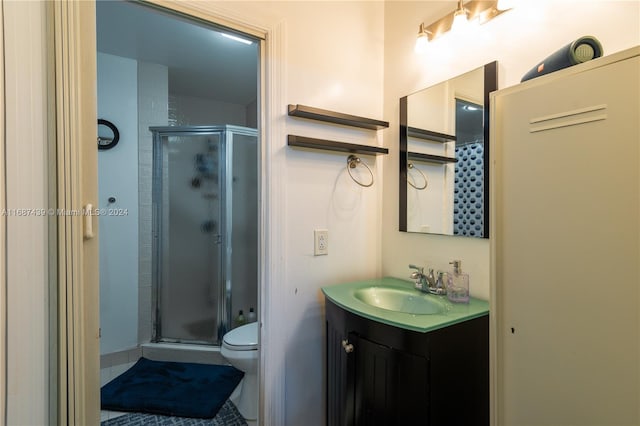 bathroom with an enclosed shower, vanity, and toilet