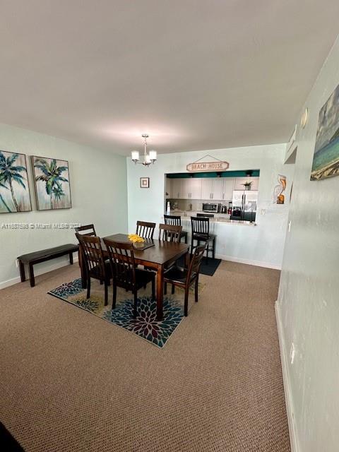 carpeted dining space featuring an inviting chandelier