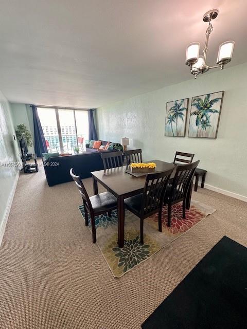 carpeted dining space featuring a chandelier