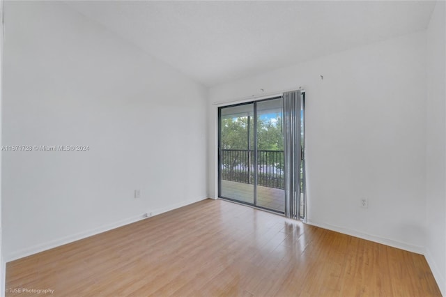 empty room with light hardwood / wood-style flooring and vaulted ceiling